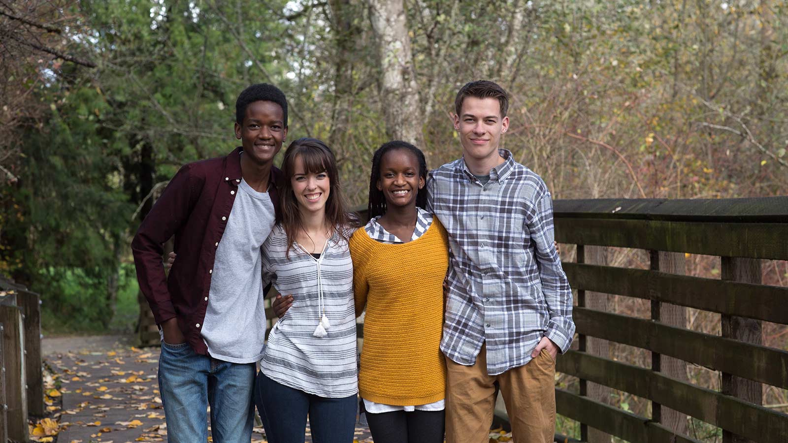 adoptive family smiling for portrait on a bridge