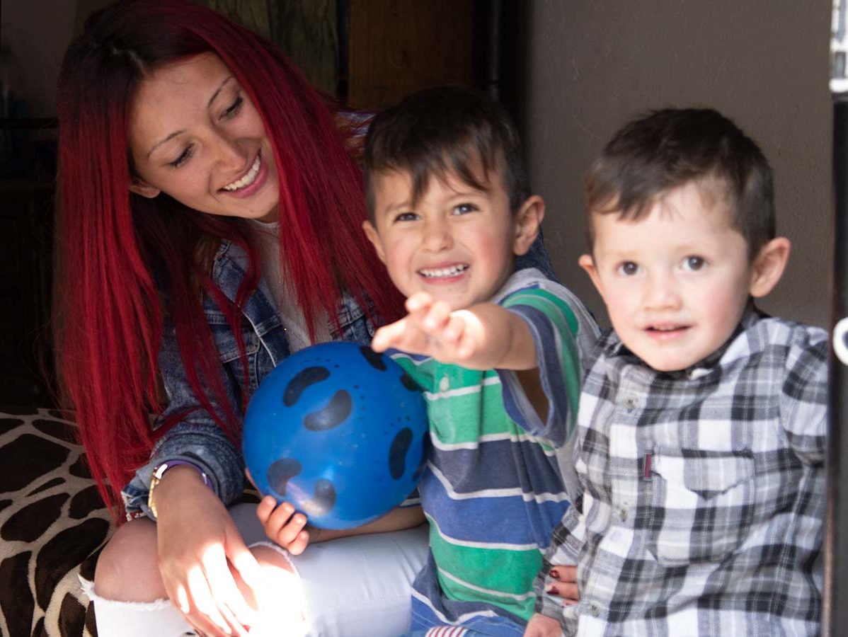 Girl smiling with two boys