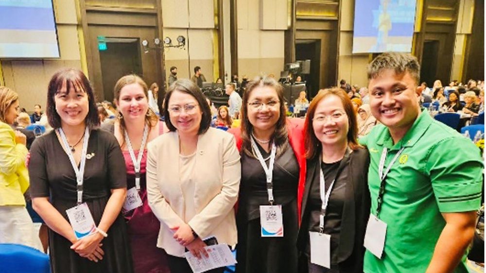 Group of people with name tags smile at camera at conference