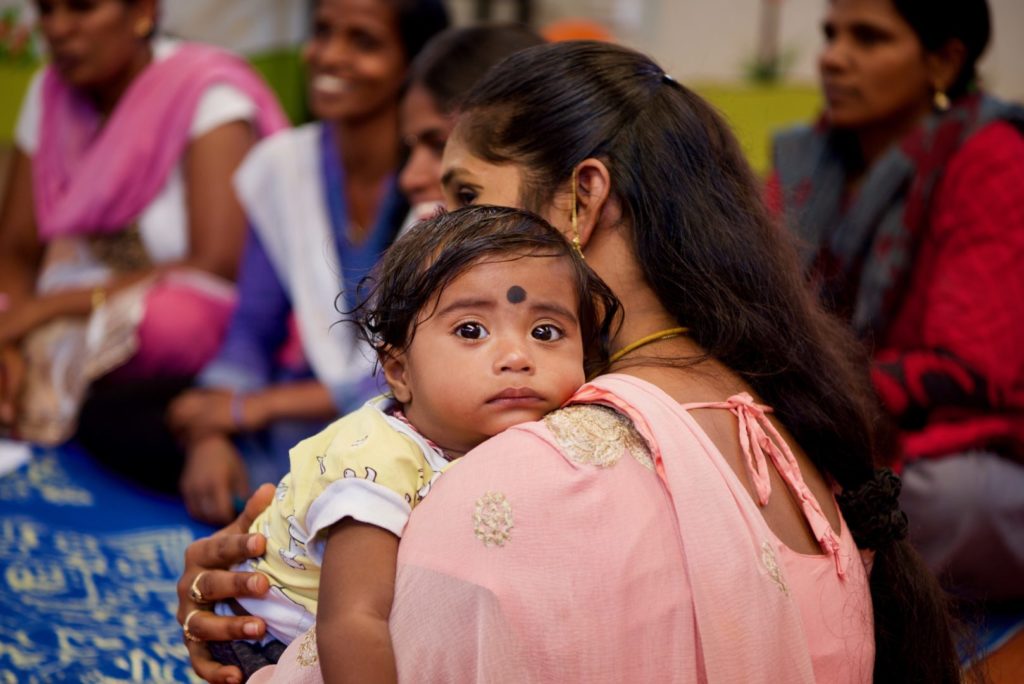 A little one rests on her mom's shoulder during the mothers' peer support group.