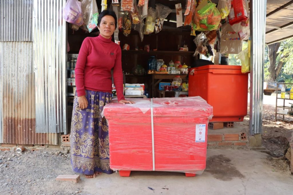 woman standing by red freezer