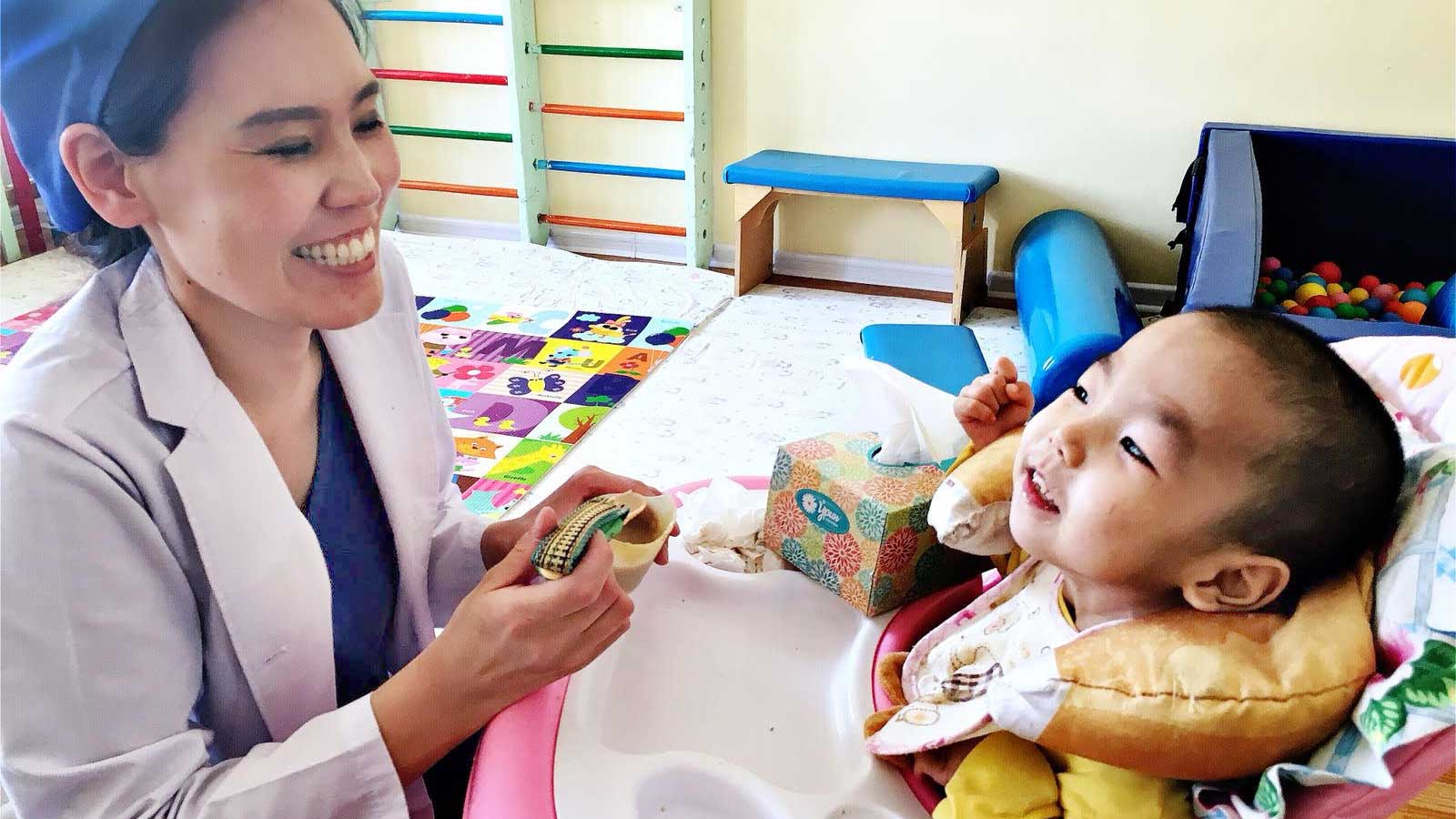 Woman feeding special needs child