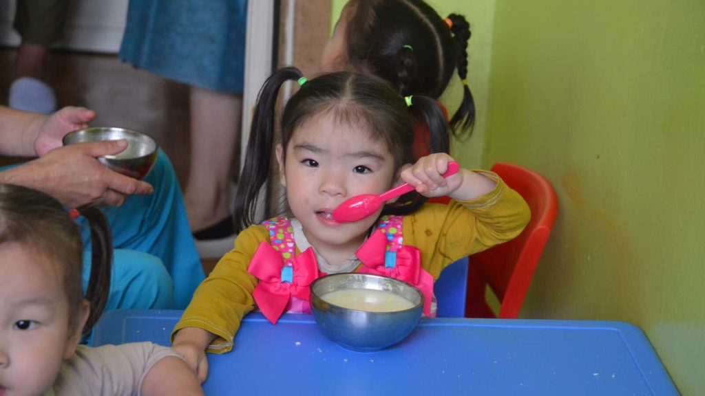 girl eating from bowl with spoon