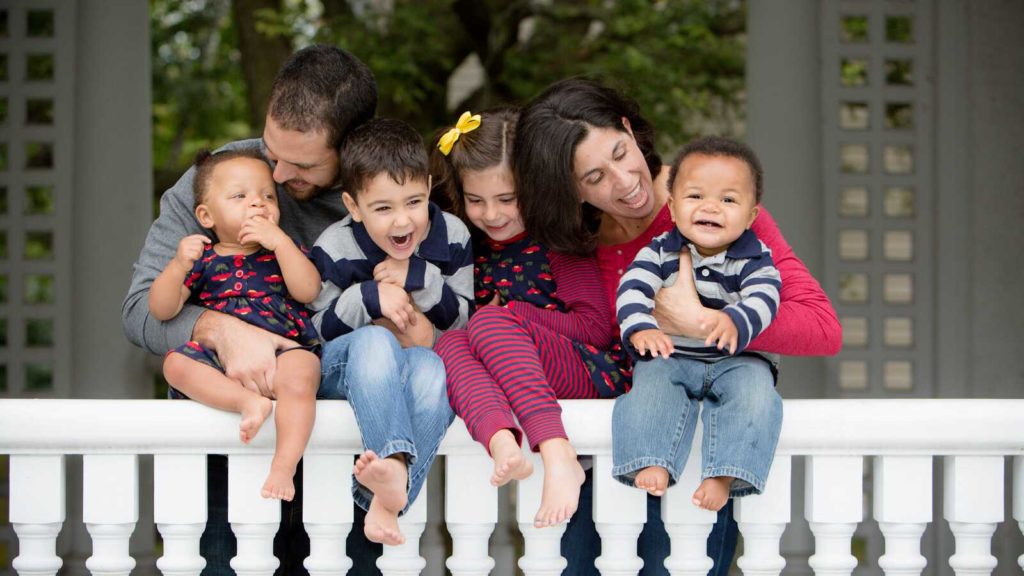 family smiling with two adopted babies